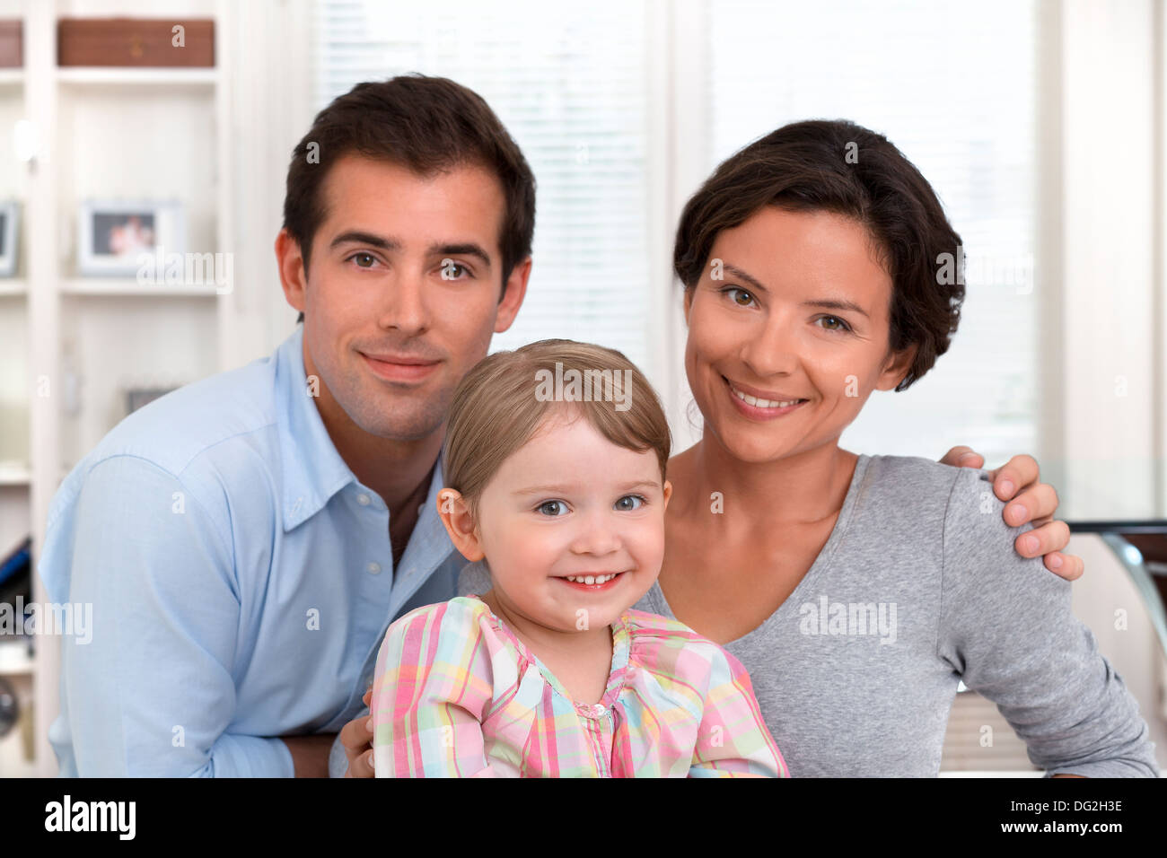 Mother father little girl daughter indoor looking camera Stock Photo