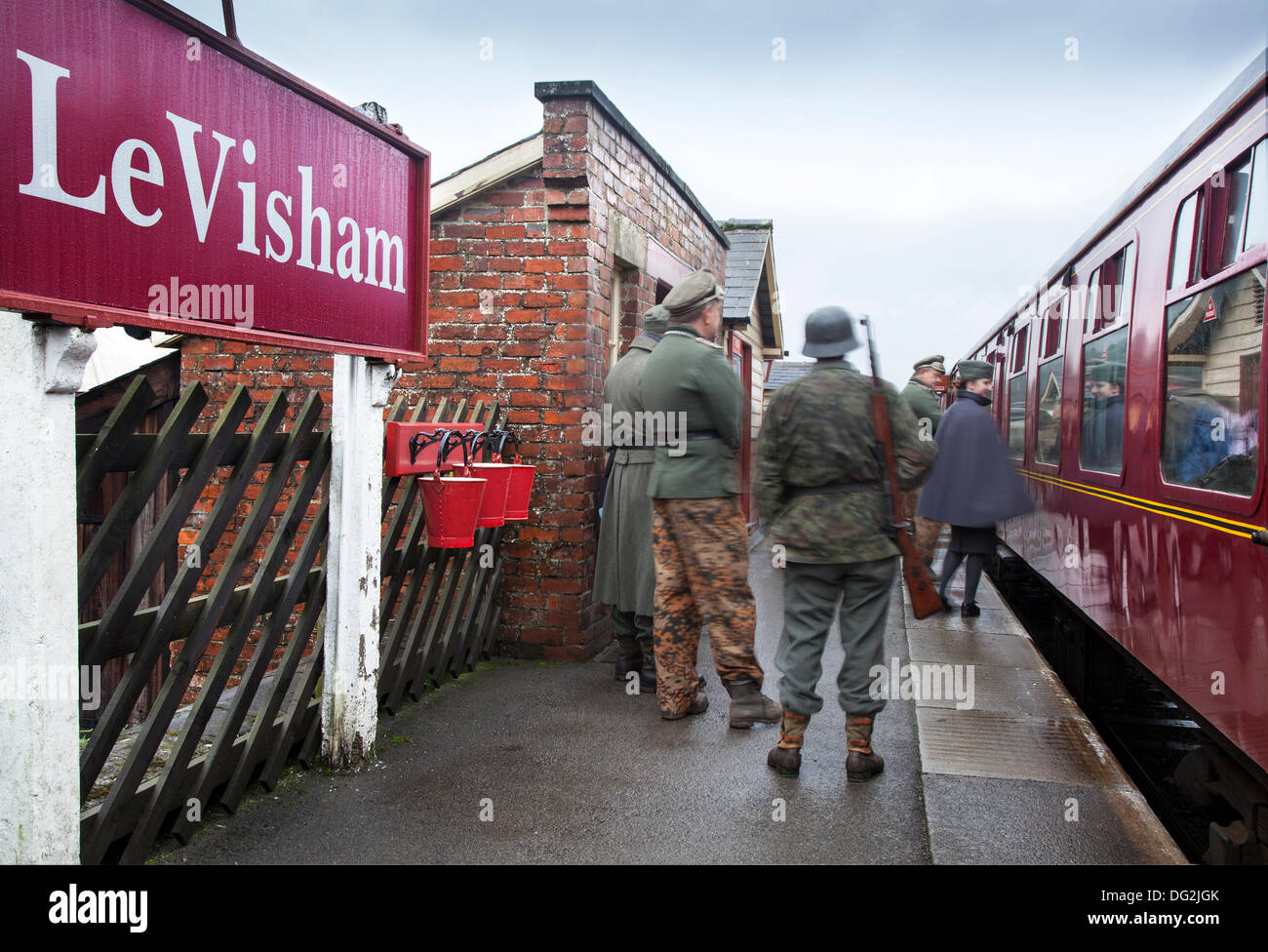 WWII train at Levisham. North Yorkshire, UK.  October, 2013. German Station Guards or Feldgendarmerie at the  ‘Railway in Wartime’  North Yorks Moors Railway (NYMR) event at Levisham Railway Station in inclement weather on weekend 12th-13th October 2013.   Levisham Station, was decorated with period posters, and French signs  during the (NYMR) ‘Wartime Weekend’ to become  ‘Le Visham’ in northern France. The gathering, a recreation of a French village occupied by World War Two, World War II, Second World War,  WWII, WW2 German troops, Stock Photo