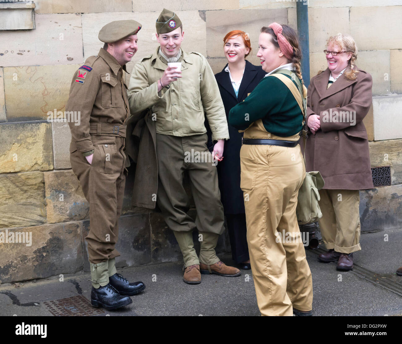 A group of friends chatting in Park Street Pickering North Yorkshire England UK in period dress for Wartime and 1940's week-end 2013.  One man isdressed as a British Royal Artillery gunner and the other as a American Paratrooper.   One woman dressed as a Land Army girl the others as civilians. Stock Photo