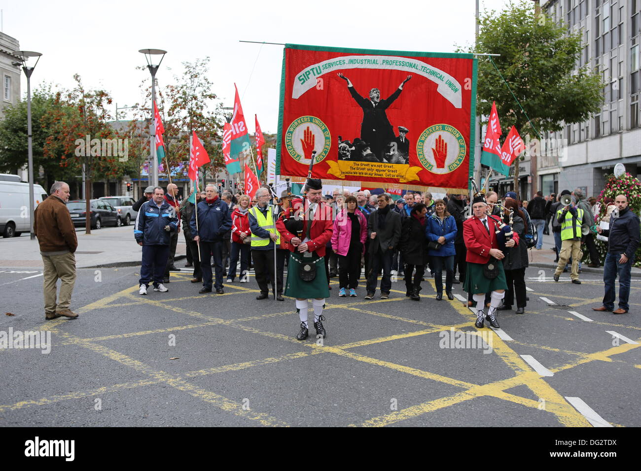 Dublin, Ireland. 12th October 2013. Members of SIPTU (Services Industrial Professional Technical Union) are being led by two bagpipers and a huge Union banner. Unions called for a protest march through Dublin, ahead of the announcing of the 2014 budget next week. They protested against cuts in Social Welfare, Health and Education and for an utilisation of alternative revenue sources by the government. © Michael Debets/Alamy Live News Stock Photo