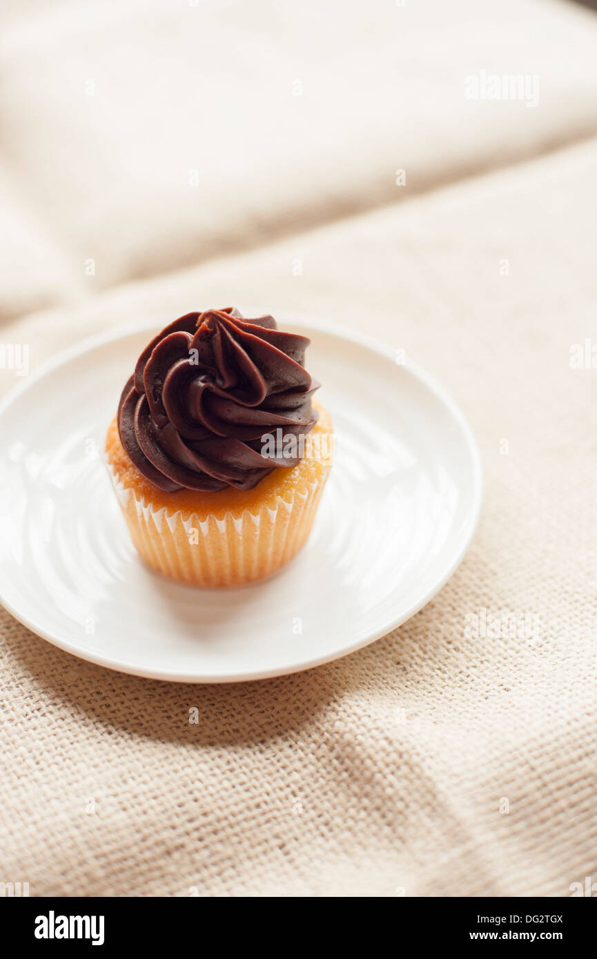 Cupcake with Chocolate Icing on White Plate Stock Photo