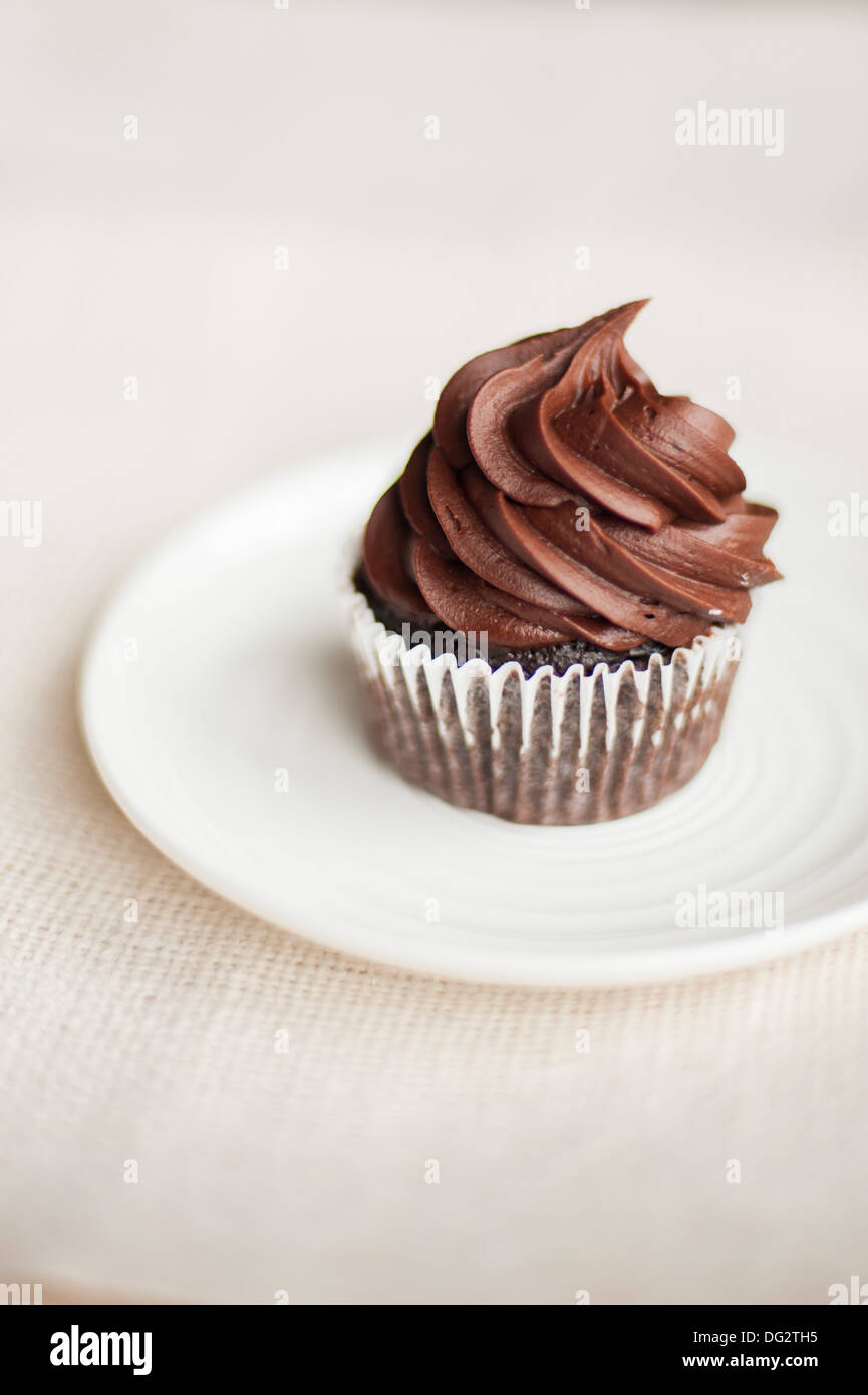 Cupcake with Chocolate Icing on White Plate Stock Photo