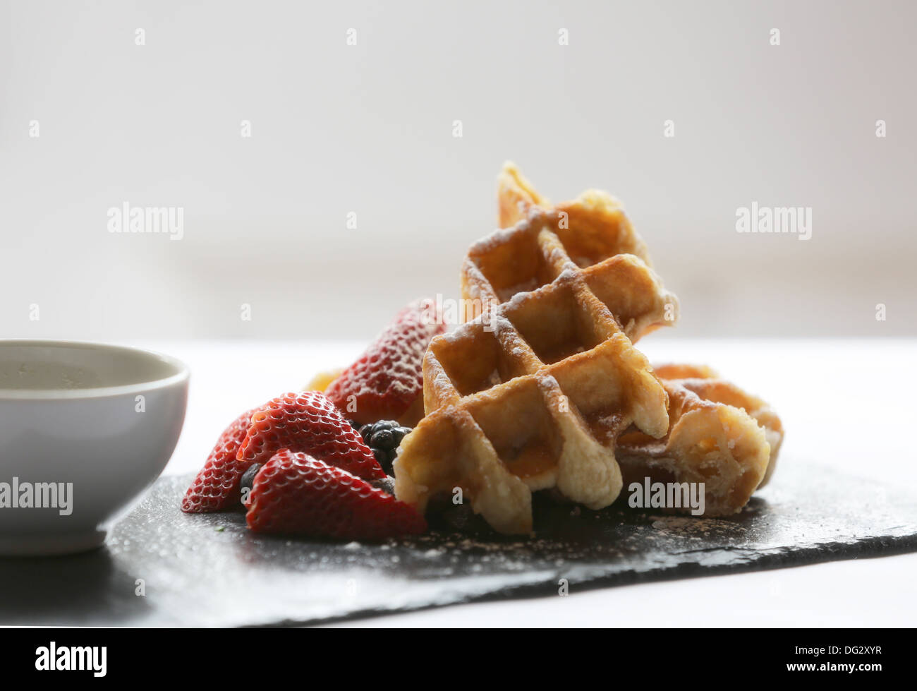 Belgian waffles with strawberries and maple syrup Stock Photo