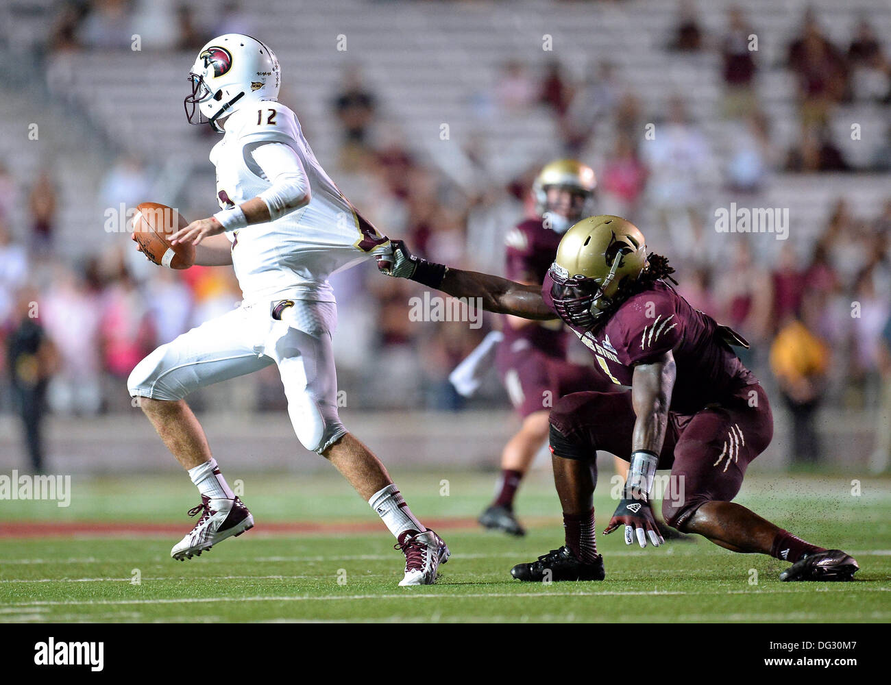 San Marcos, TX, USA. 12th Oct, 2013. ULM quarterback Brayle Brown #12 pulls away from Texas State linebacker Michael Orakpo #1 during second half of NCAA football game at Jim Wacker Field in San Marcos, TX. ULM defeat Texas State 21-14. © csm/Alamy Live News Stock Photo