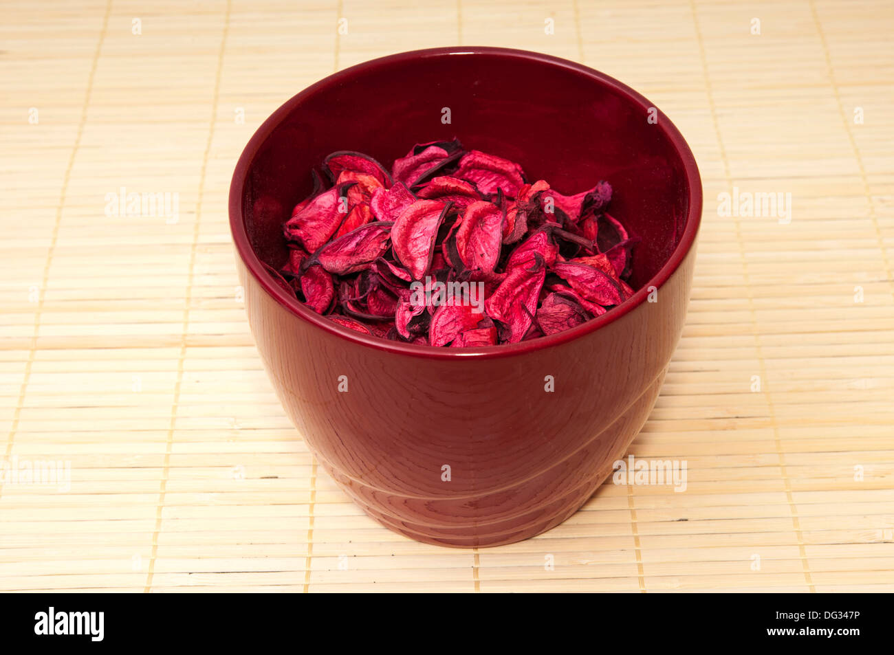 pot with pink petals on a wooden background Stock Photo