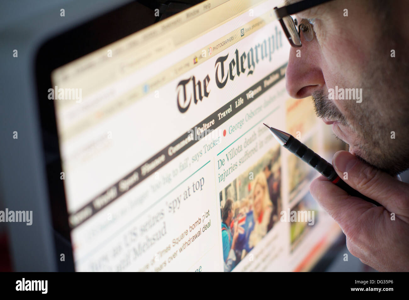 Adult male looking at the online internet website of the daily telegraph UK based british newspaper Stock Photo
