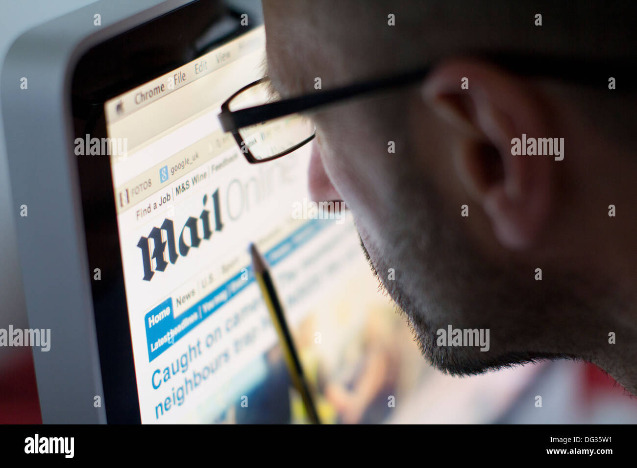 Adult male browsing the homepage of the Daily Mail website on a computer screen, highlighting the popularity of the UK-based online tabloid newspaper and its role in British digital media consumption Stock Photo