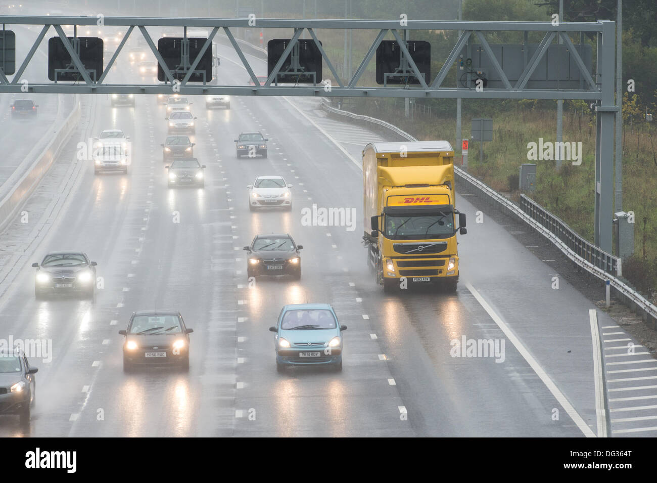 13th October 2013. M25 Essex. Heavy rain causes hazardous driving conditions for traffic passing through Essex on the M25. Surface water and spray reducing visibility makes for difficult driving. Stock Photo