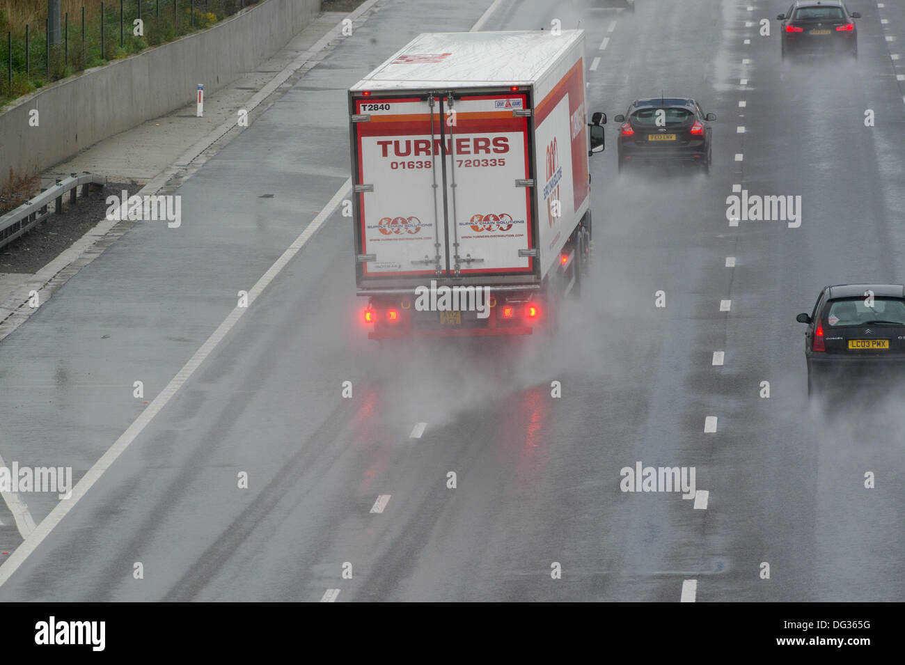 13th October 2013. M25 Essex. Heavy rain causes hazardous driving conditions for traffic passing through Essex on the M25. Surface water and spray reducing visibility makes for difficult driving. Stock Photo