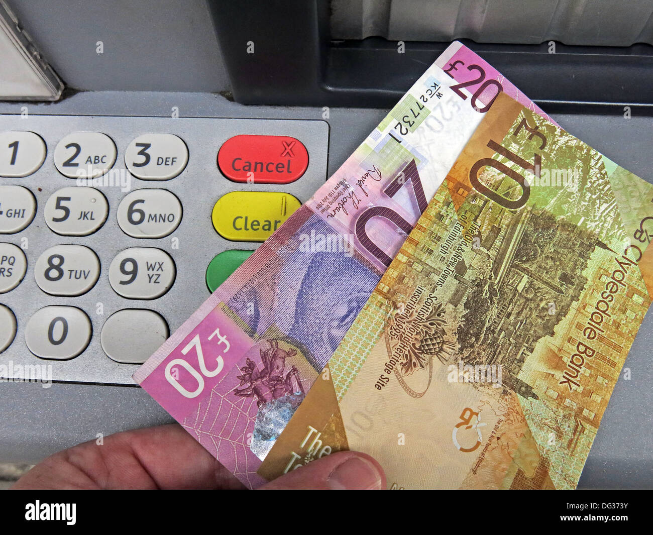 Scots Pound Sterling Notes being pulled from a Scottish Clydesdale bank ATM cash dispensing machine , Scotland UK Stock Photo