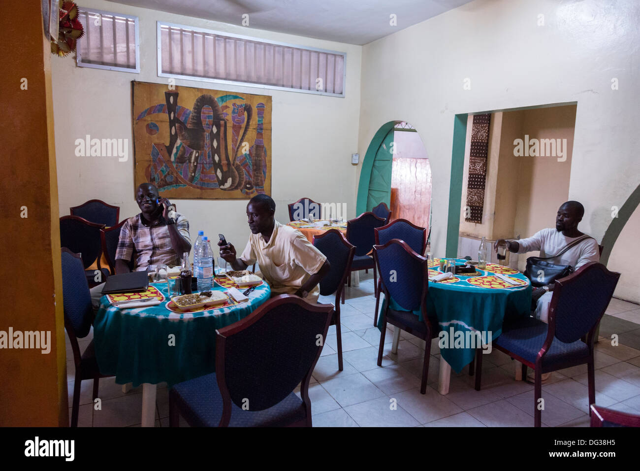 Senegal. Diners Using Cell Phones in a Roadside Restaurant, Diourbel (Djourbel). Stock Photo