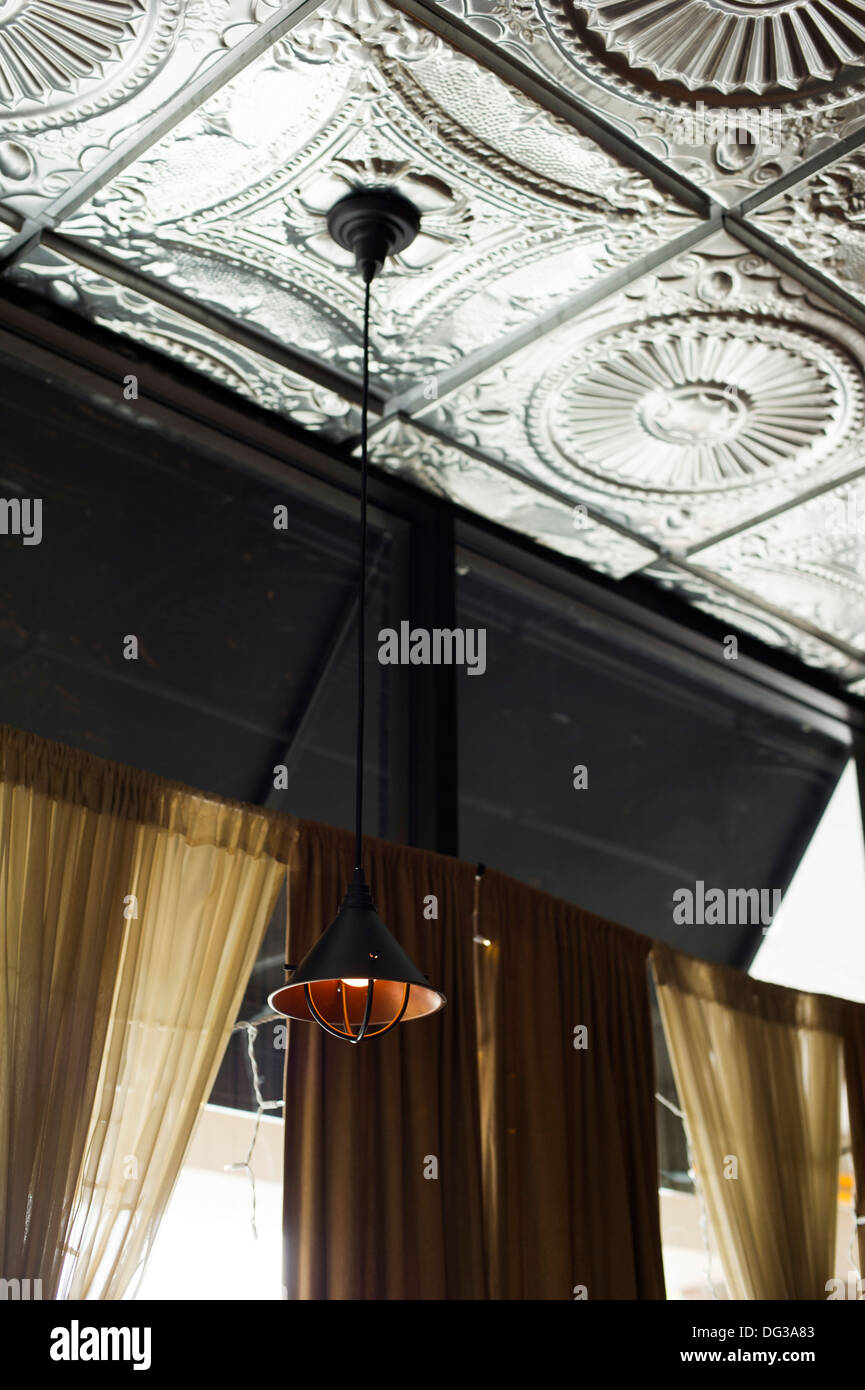 Tin Ceiling and Hanging Light Fixture, Low Angle View Stock Photo
