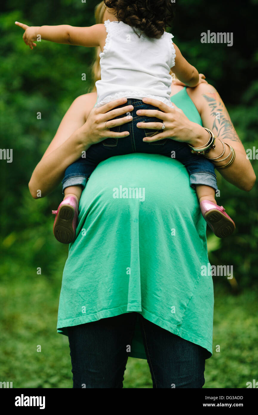 Pregnant Woman Holding Young Child on Belly Stock Photo