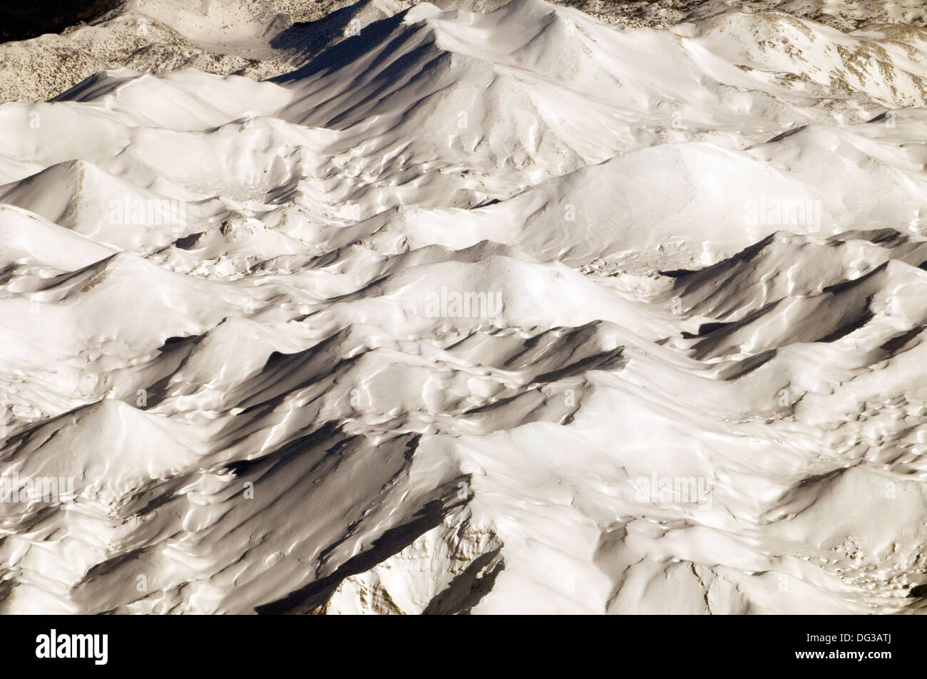 Aerial view of glistening white snow-clad mountain range of the Alps Stock Photo