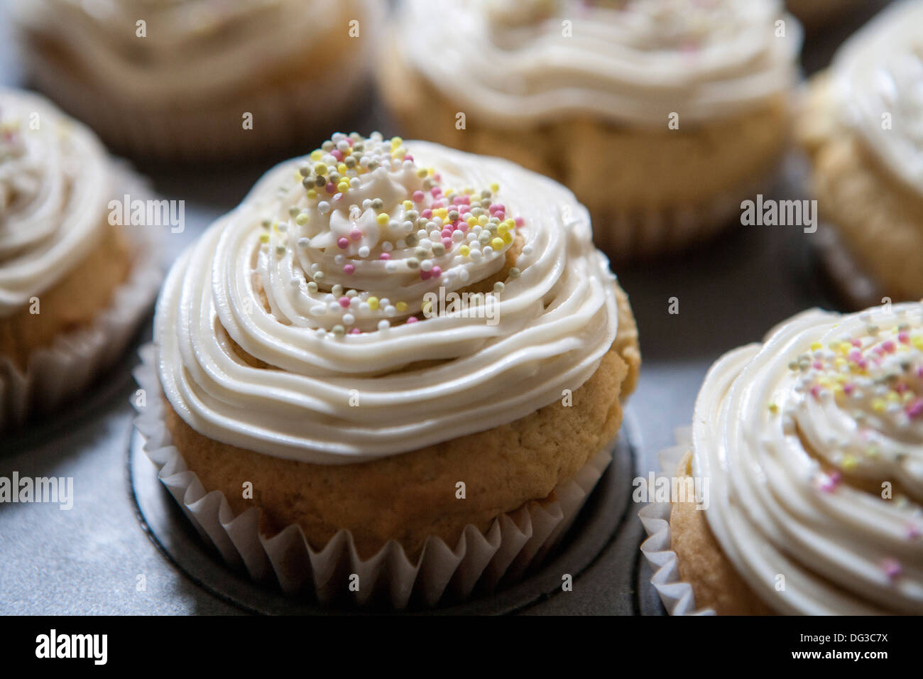 Lemon Vanilla Cupcakes with Cream Cheese Icing and Sprinkles, Close-Up Stock Photo