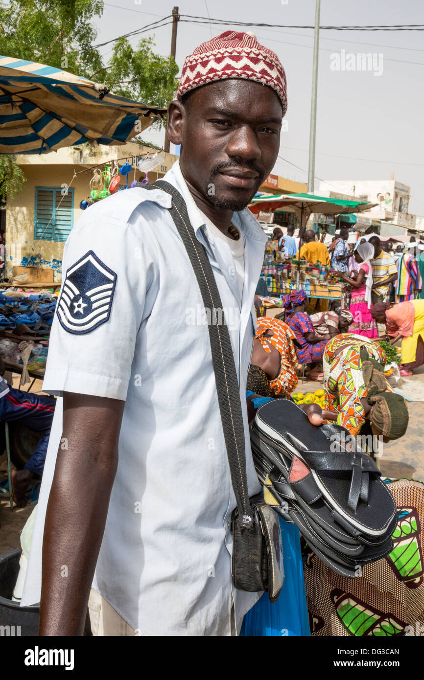 Senegal, Touba. Young Man Selling Sandals in the Market. Stock Photo