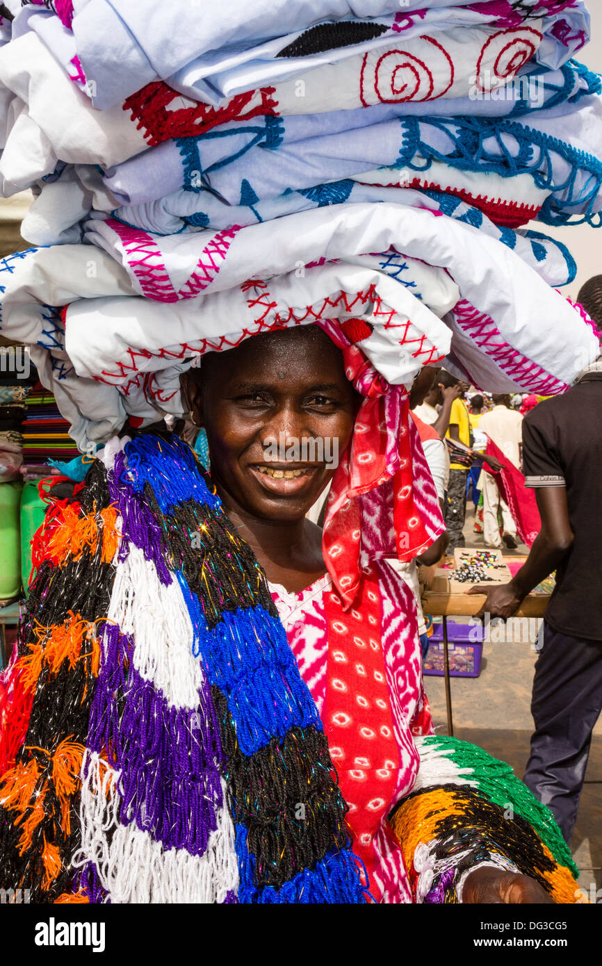 Senegal, Touba. Woman Selling Cloth in the Market. Stock Photo