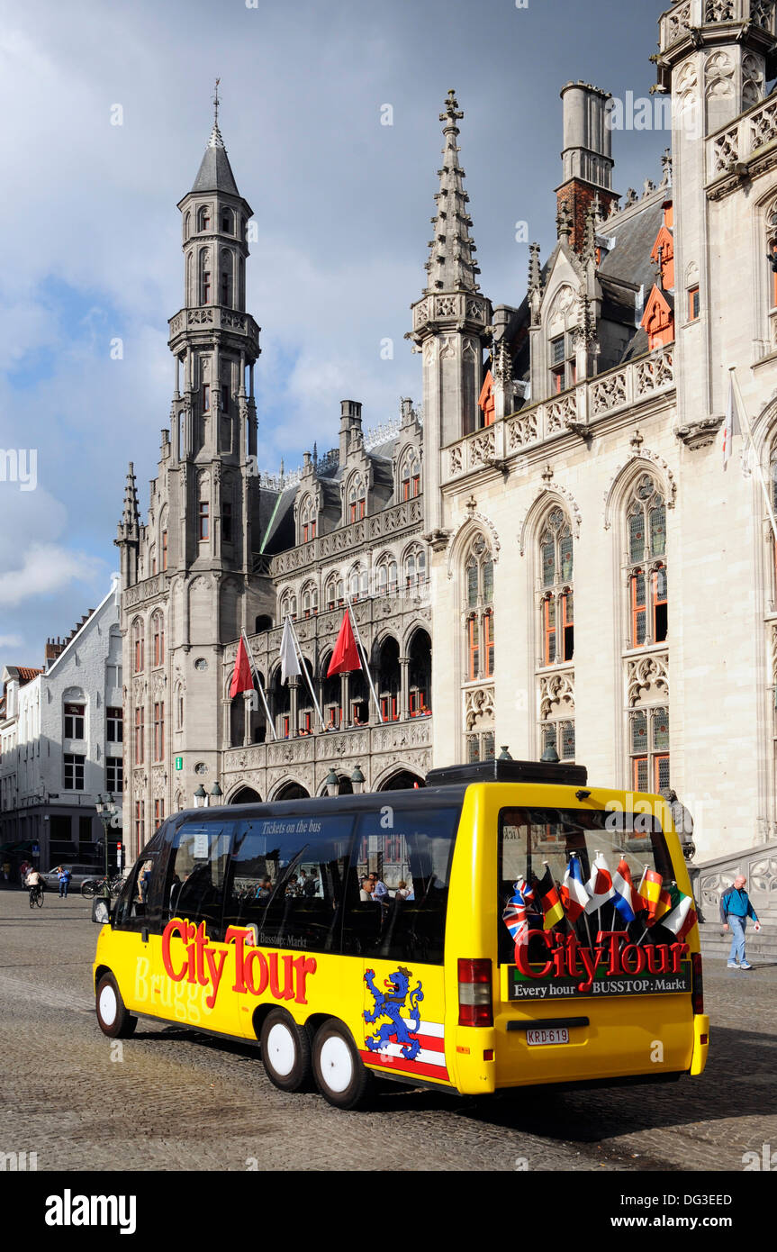 A tourist city tour bus in the Market Square (Markt) Bruges, Belgium Stock Photo