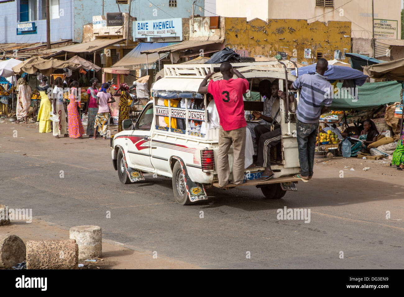 Senegal, Touba. Local Transport. Pick-ups with Young Men usually Hanging on the Back Running Board, Passengers Inside. Stock Photo