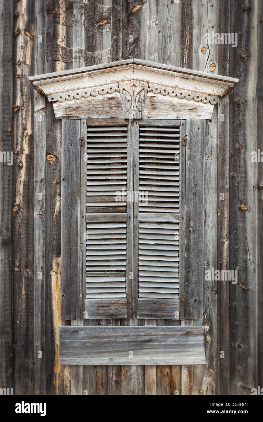 Weathered wooden shutters covering window of old wooden building, South Dakota Stock Photo