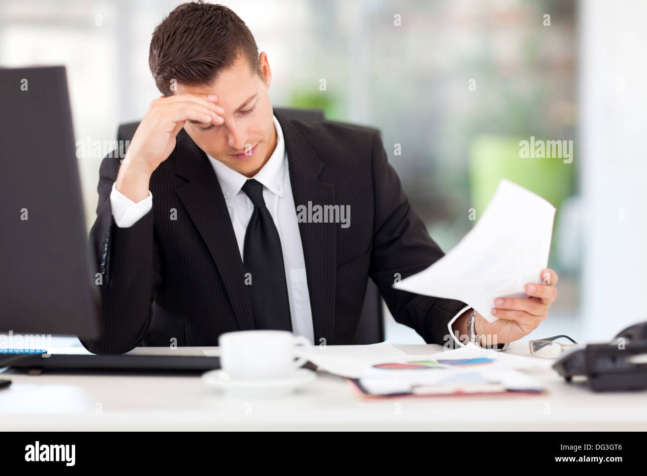 stressed businessman reading documents in office Stock Photo
