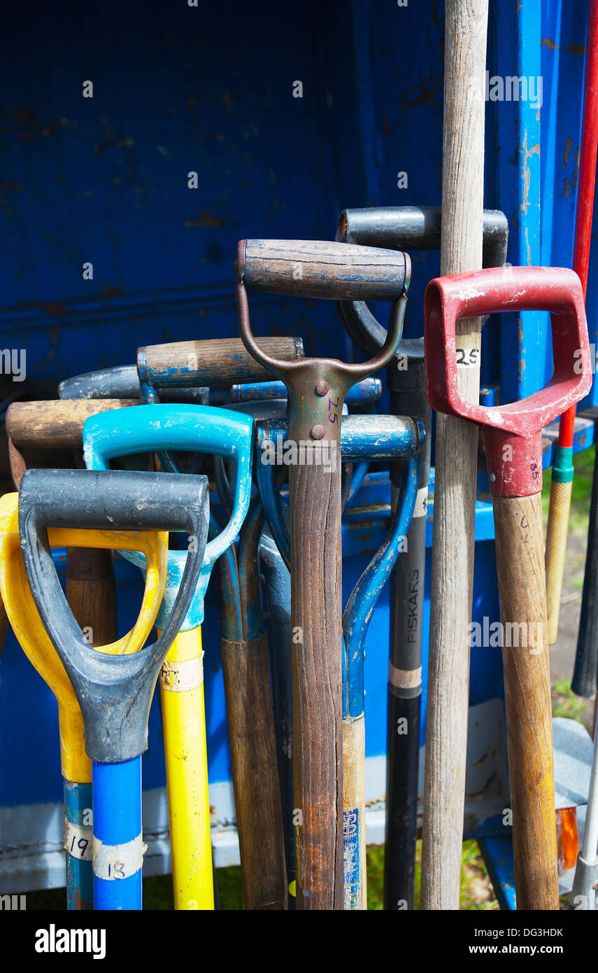 A group of used, secondhand, garden forks, tools, spades on sale on a stall at an outdoor market. Stock Photo