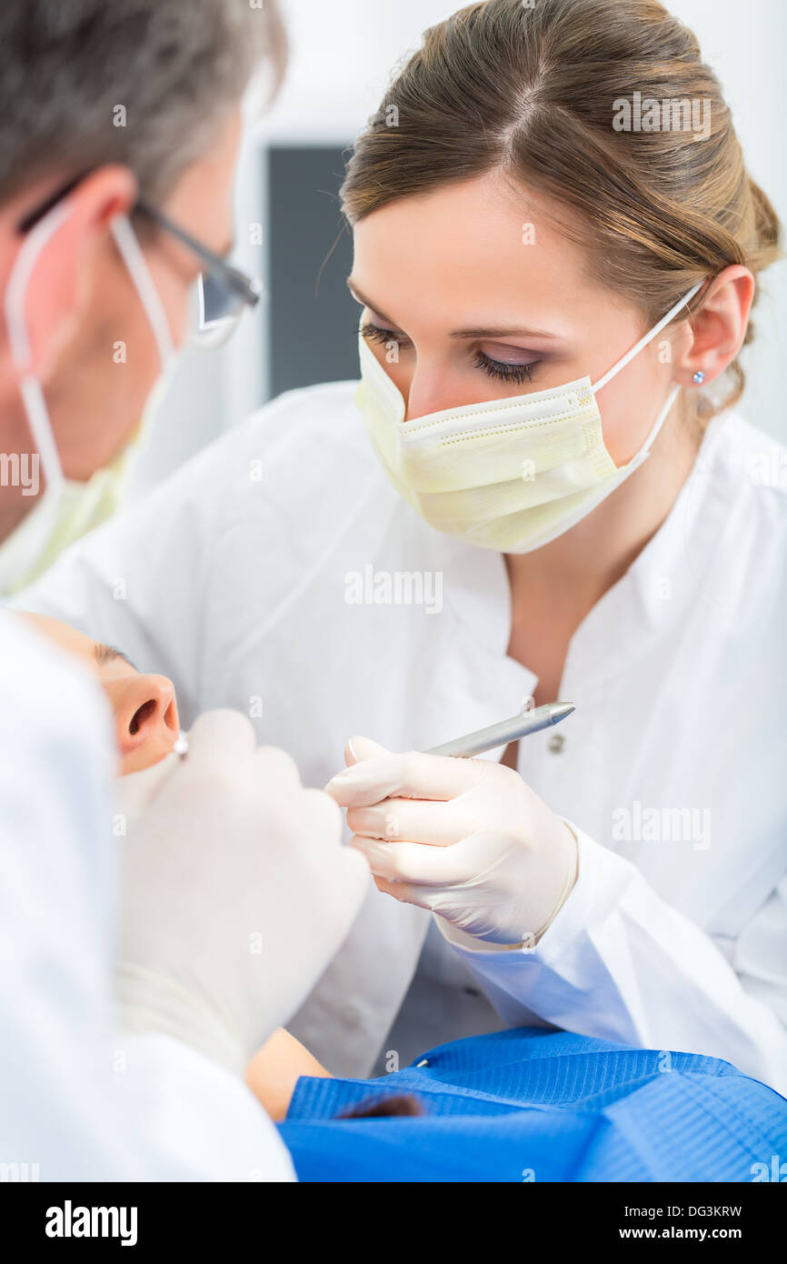 Female patient with dentist and assistant in a dental treatment