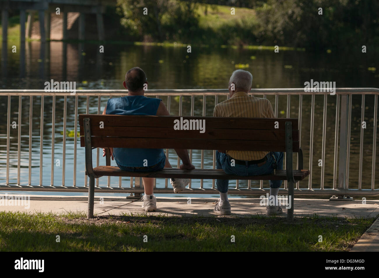 Two men sitting on a bench at the Ed Stone Park in Central Florida USA Stock Photo
