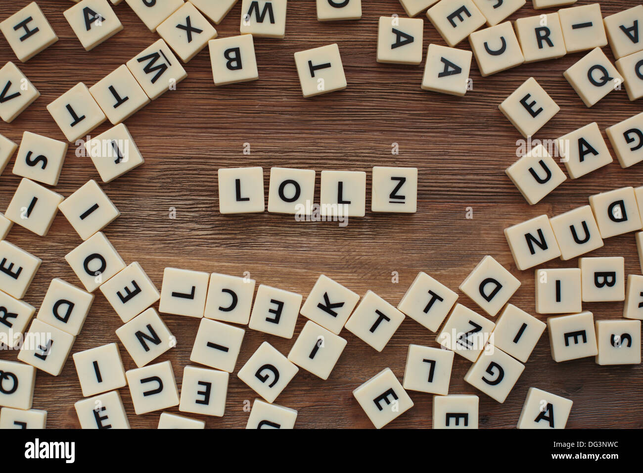 Plastic letters from a childrens' spelling game on a wooden table spell "LOLZ" Stock Photo