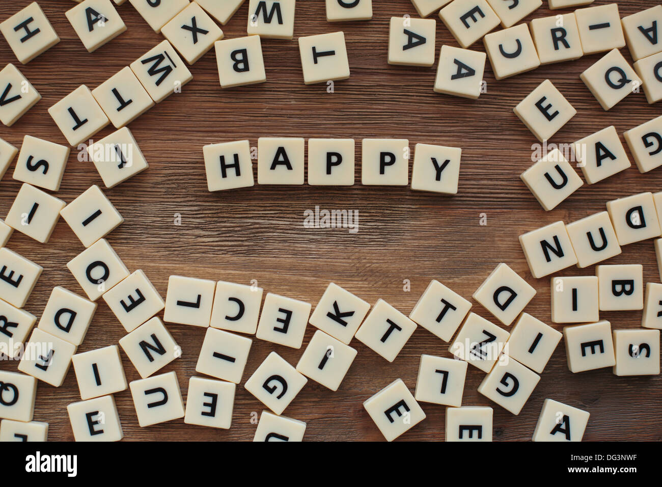 Plastic letters from a childrens' spelling game on a wooden table spell 'Happy' Stock Photo