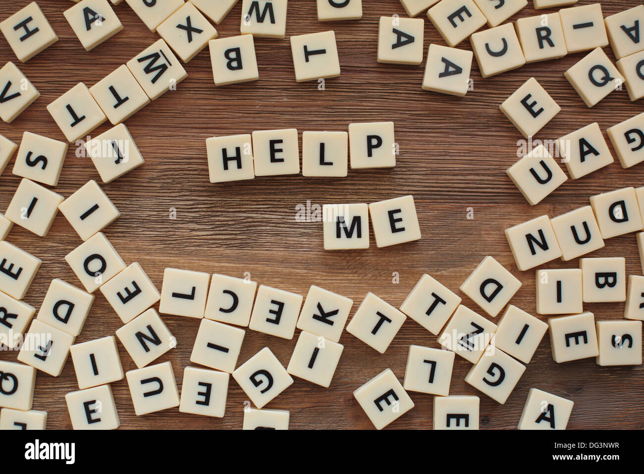 Plastic letters from a childrens' spelling game on a wooden table spell  "help me" Stock Photo