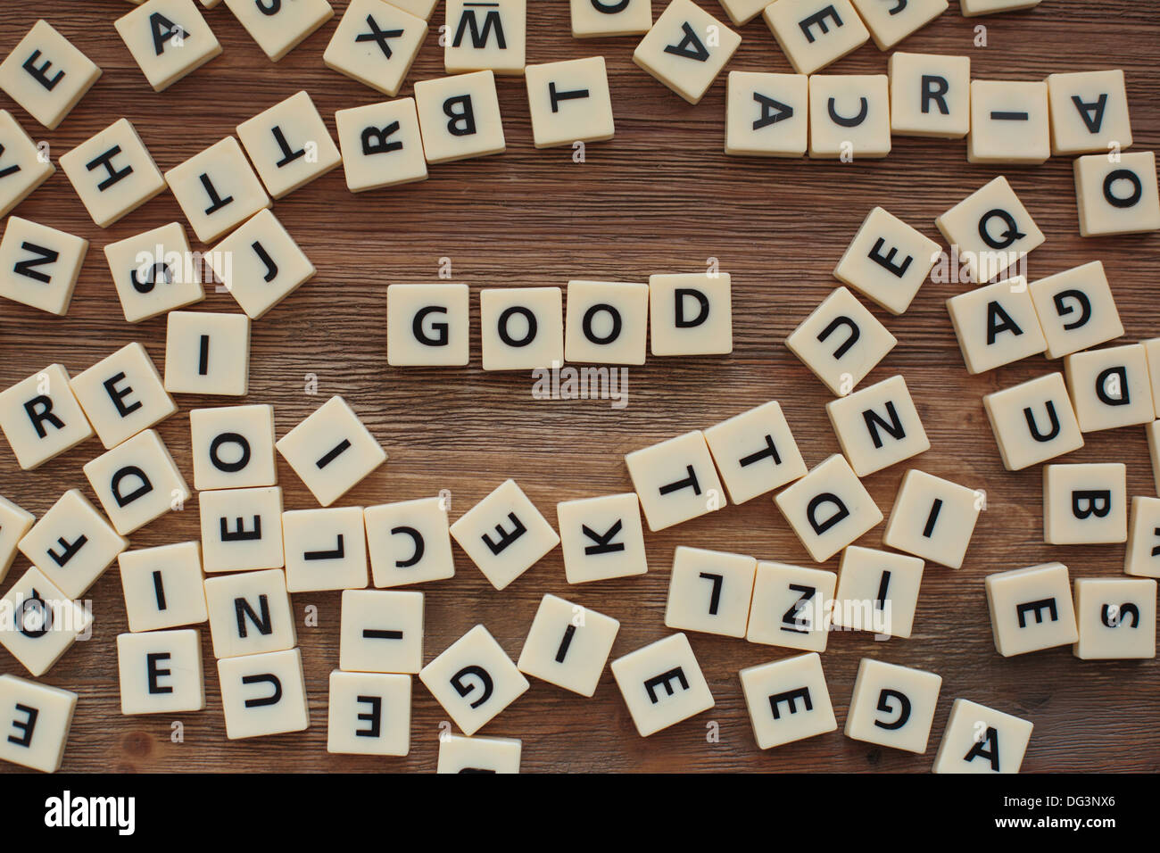 Plastic letters from a childrens' spelling game on a wooden table spell the word 'good' Stock Photo