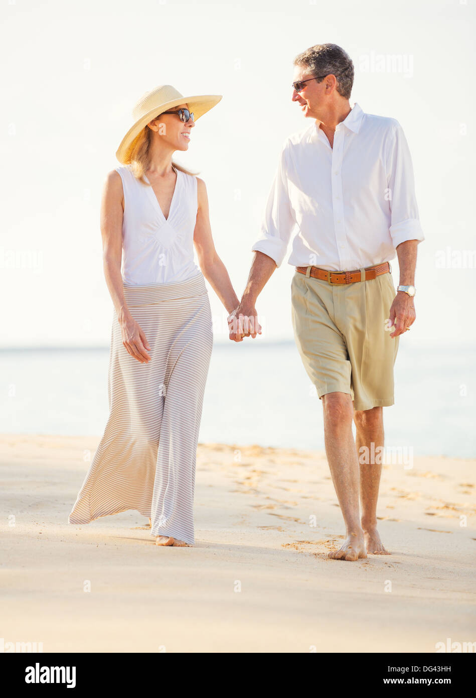 Happy Romantic Middle Aged Couple Enjoying Walk on the Beach Stock Photo