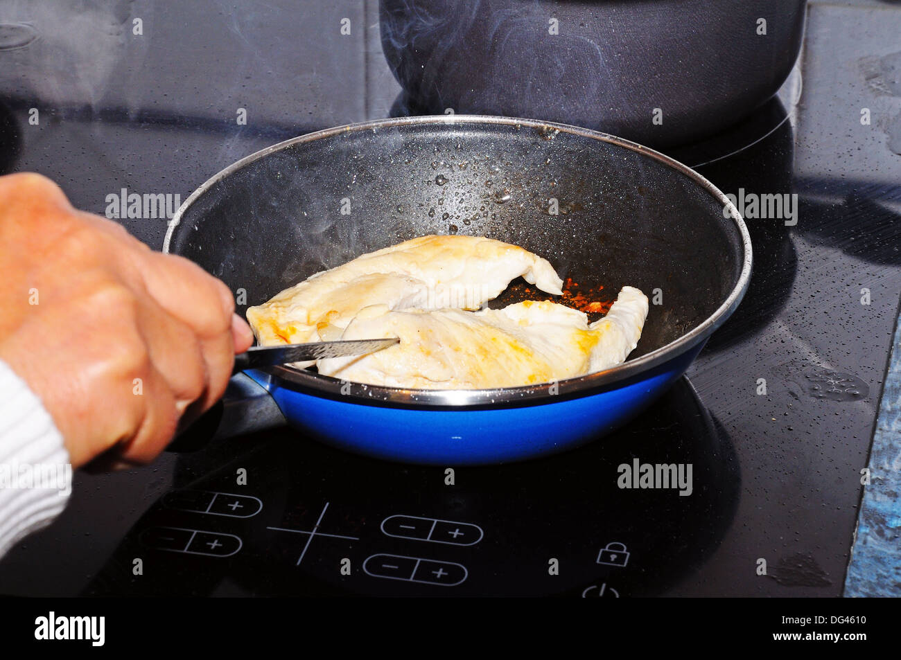 Pan frying chicken fillets Stock Photo Alamy