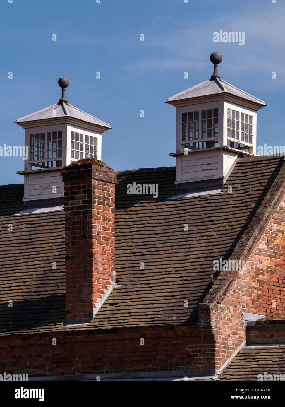 Two old rectangular ornate glazed Dovecotes above red tiled pitched roof, Calke Abbey, Ticknall, Derbyshire, England, UK Stock Photo