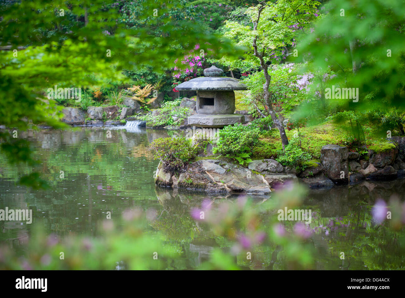 Stone lantern in a Japanese garden on a rainy day. Selective focus on the lantern. Stock Photo