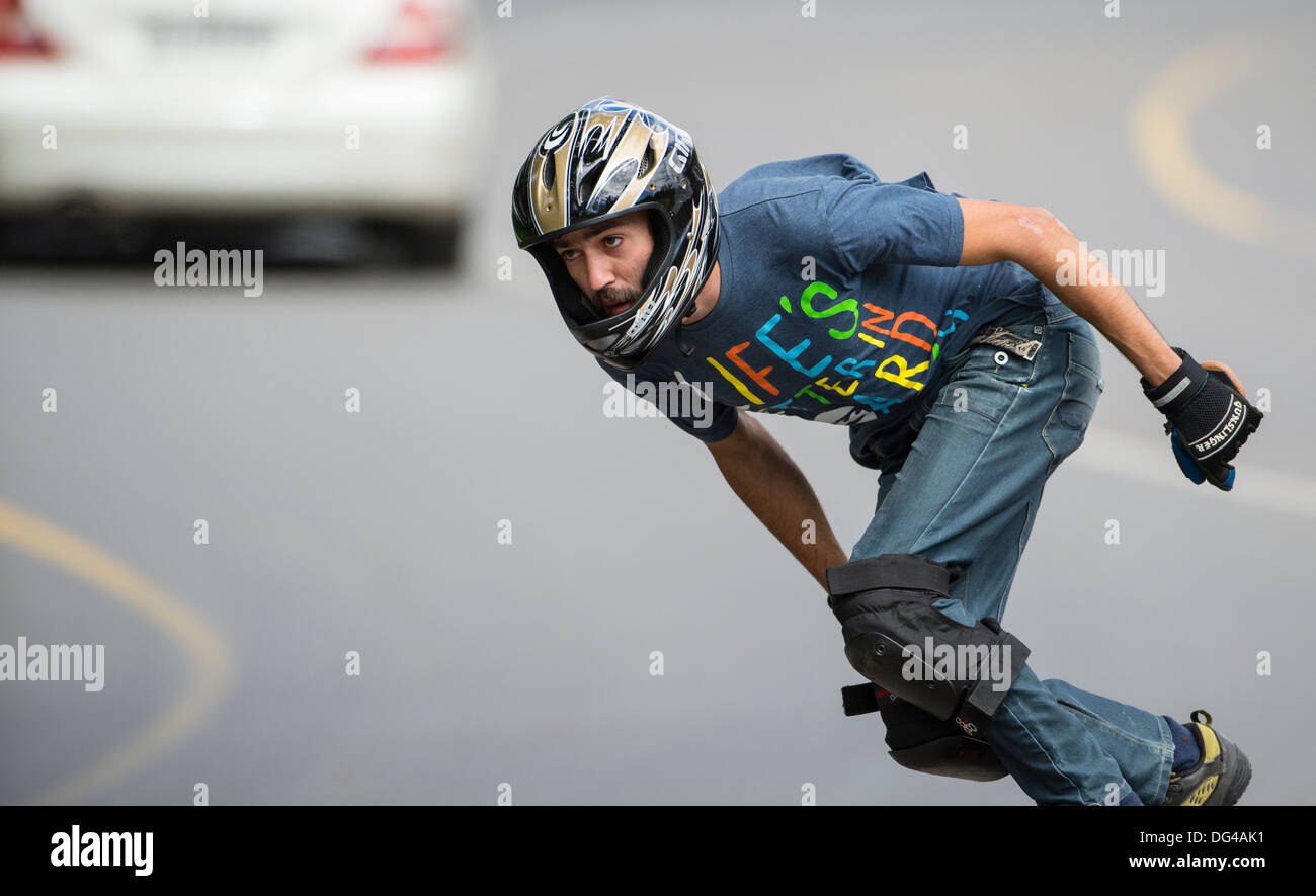 skateboard longboard man training downhill on public road with a vehicle  driving in background Stock Photo - Alamy