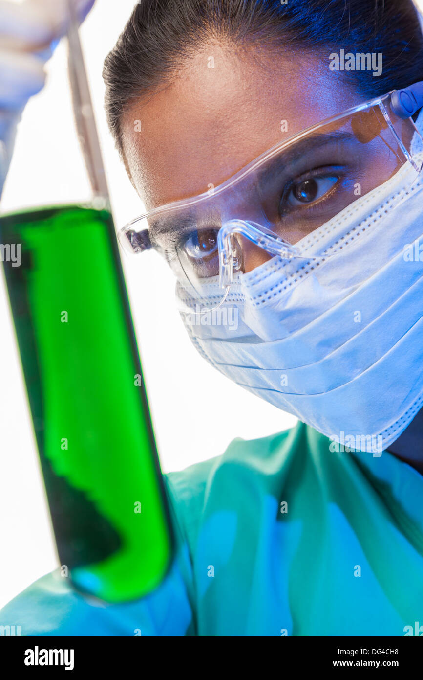 Asian Indian female medical or scientific researcher or doctor looking at a green solution in a laboratory Stock Photo
