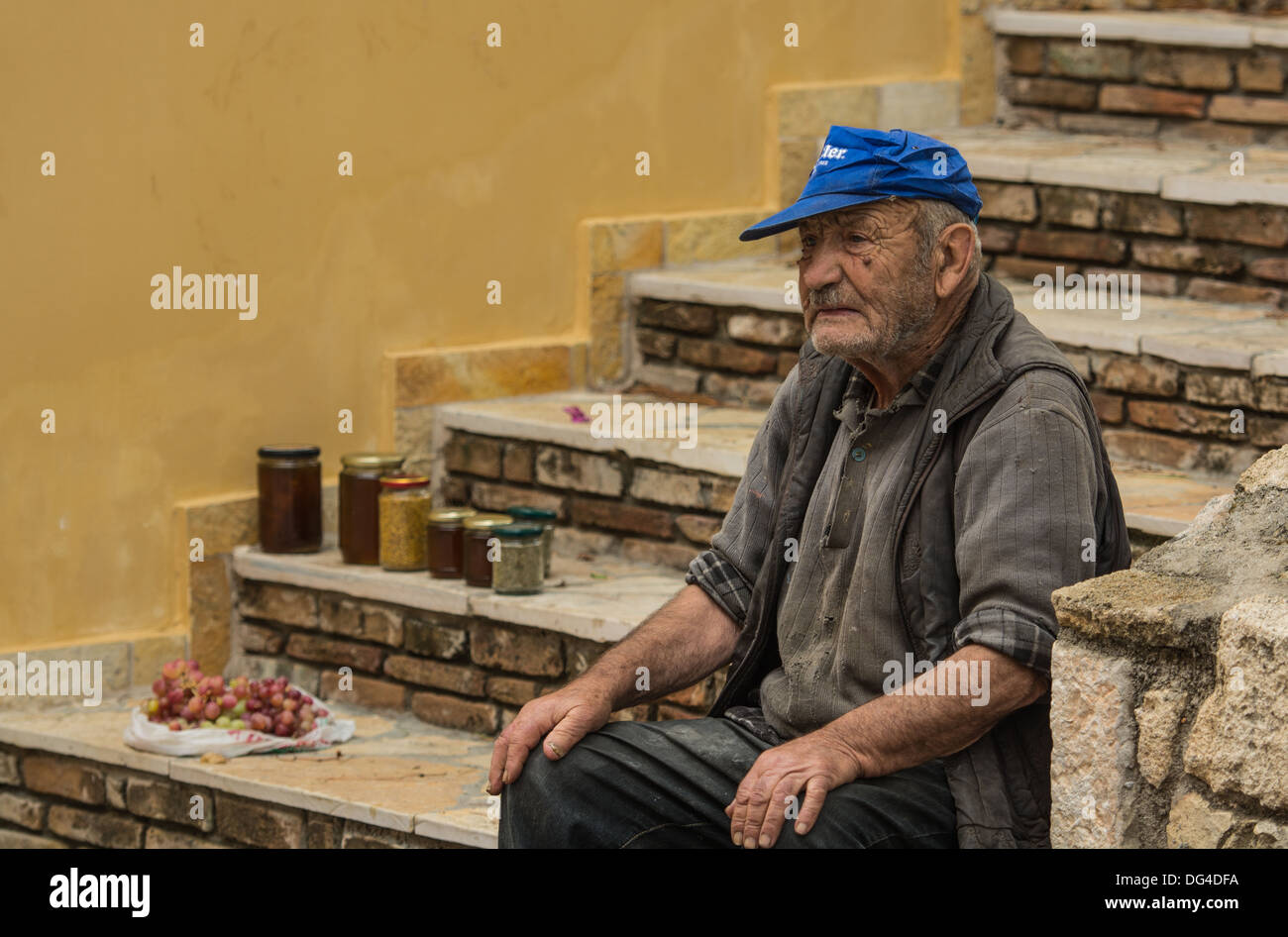 Old Tramp selling honey and grapes to tourists Stock Photo