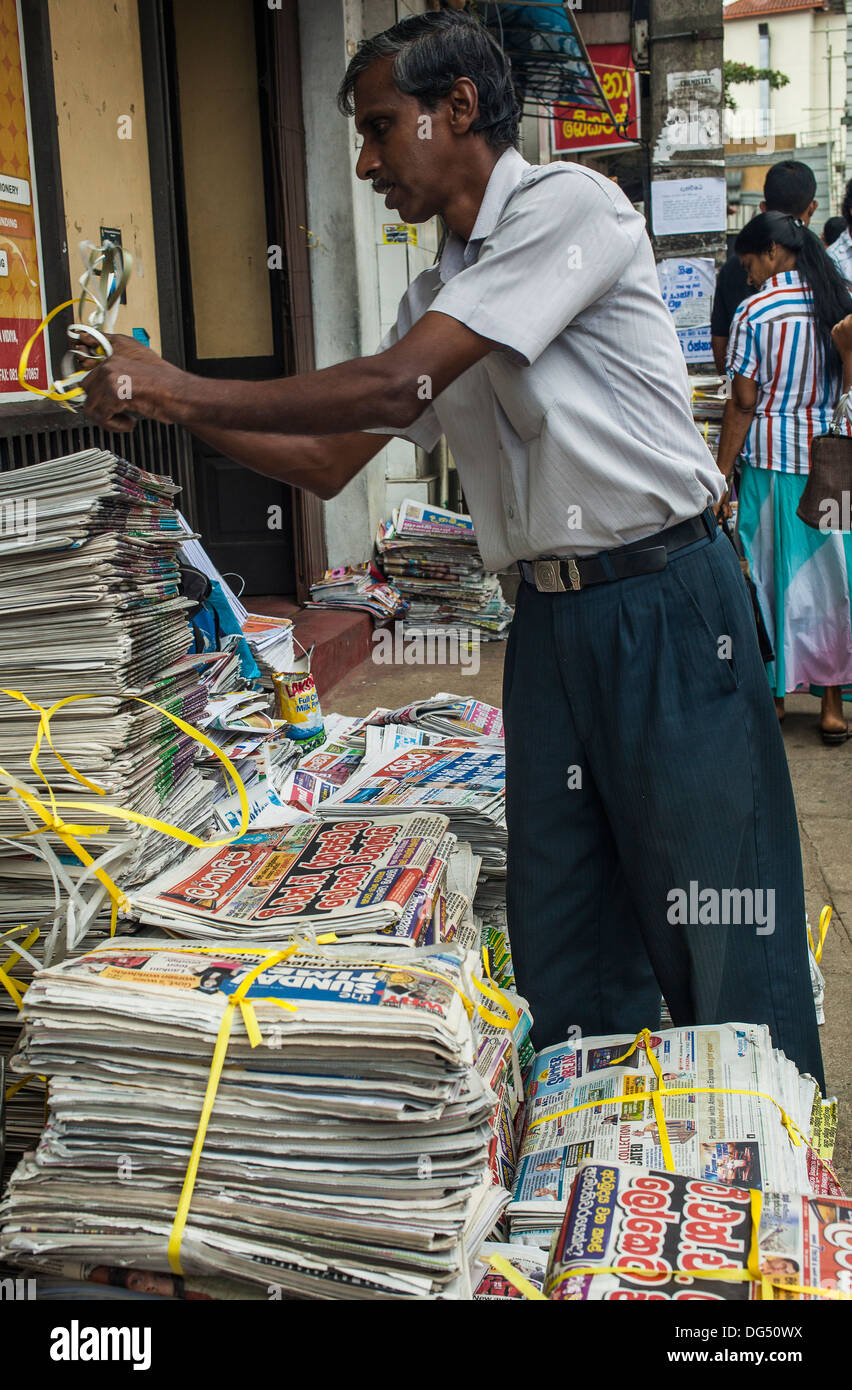 Unidentified news paper vendor unpacking morning Hindi newspapers on the street Stock Photo