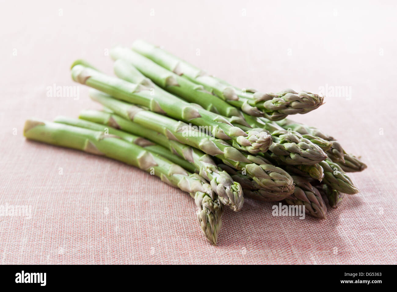 Bunch of green asparagus on red fabric Stock Photo