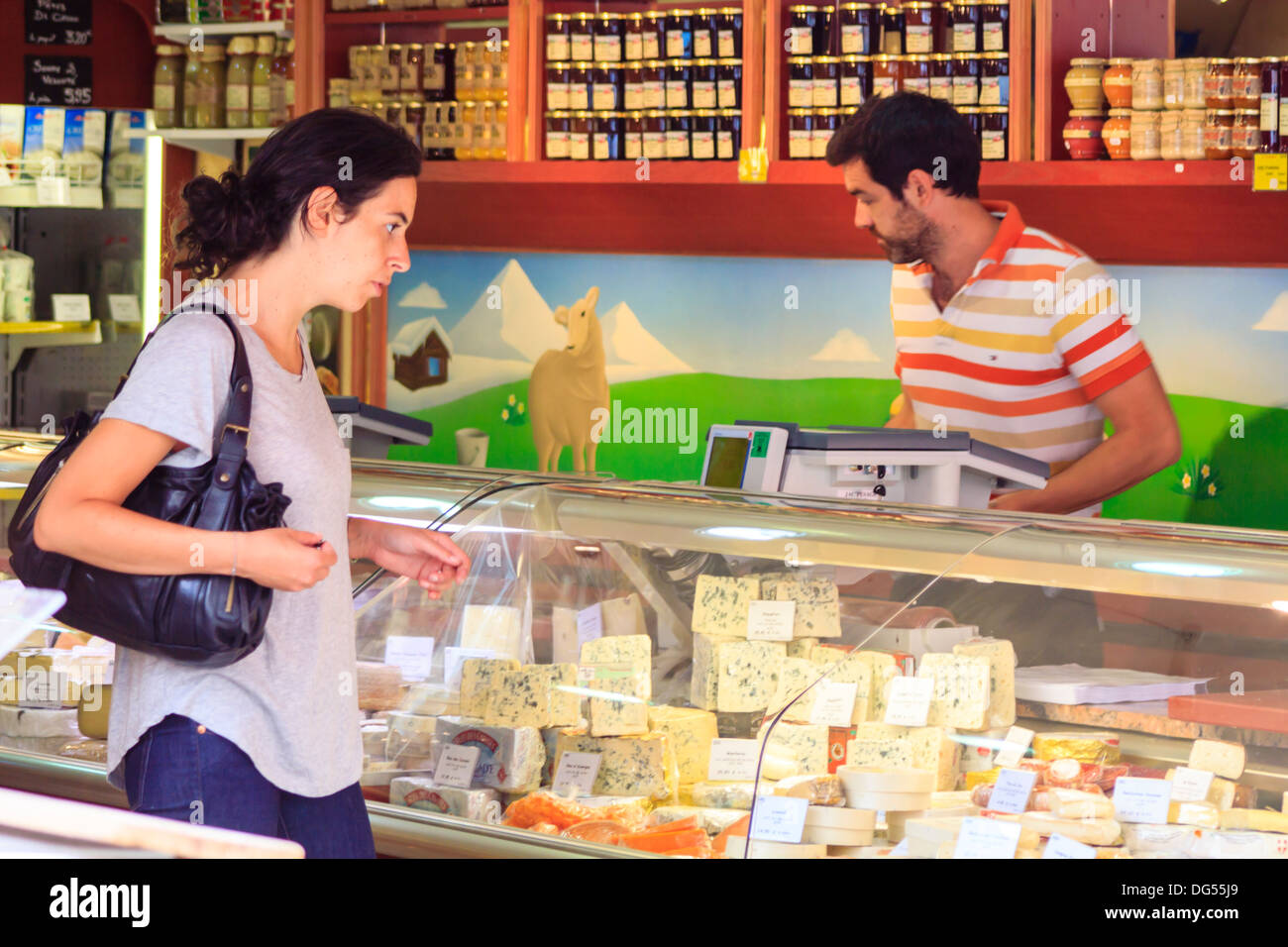 French cheese shop with dozens of kinds of cheeses and female customer