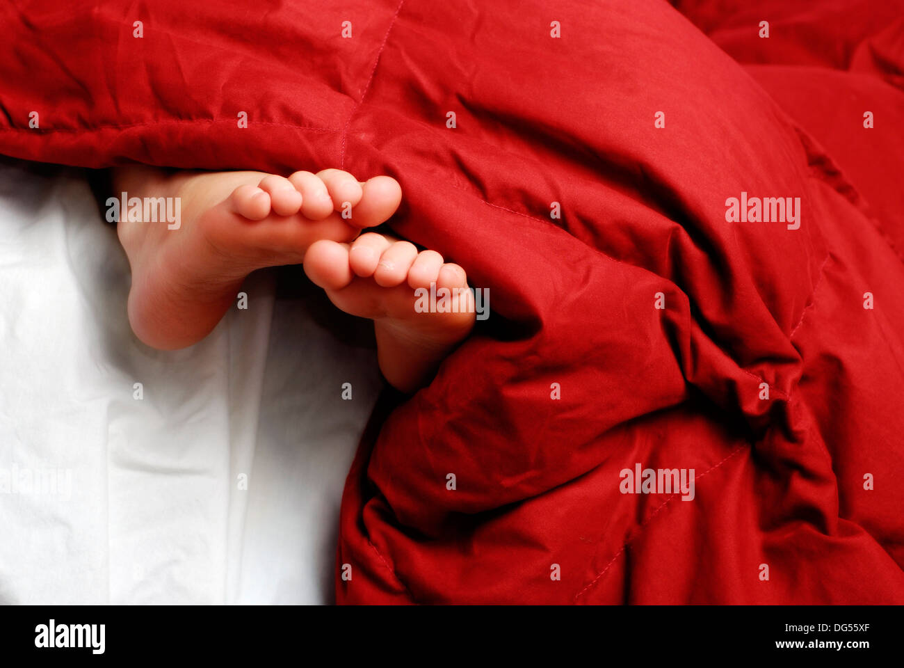 Little girl sleeping with feet poking out of blankets Stock Photo Alamy
