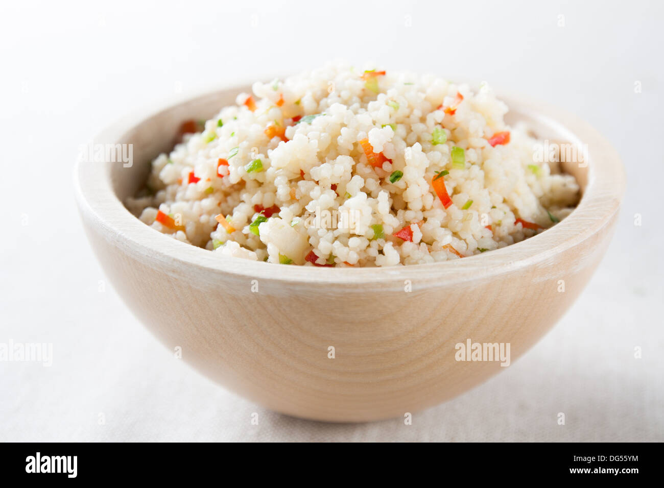 Bowl with cous cous salad with peppers, onion and cucumber Stock Photo