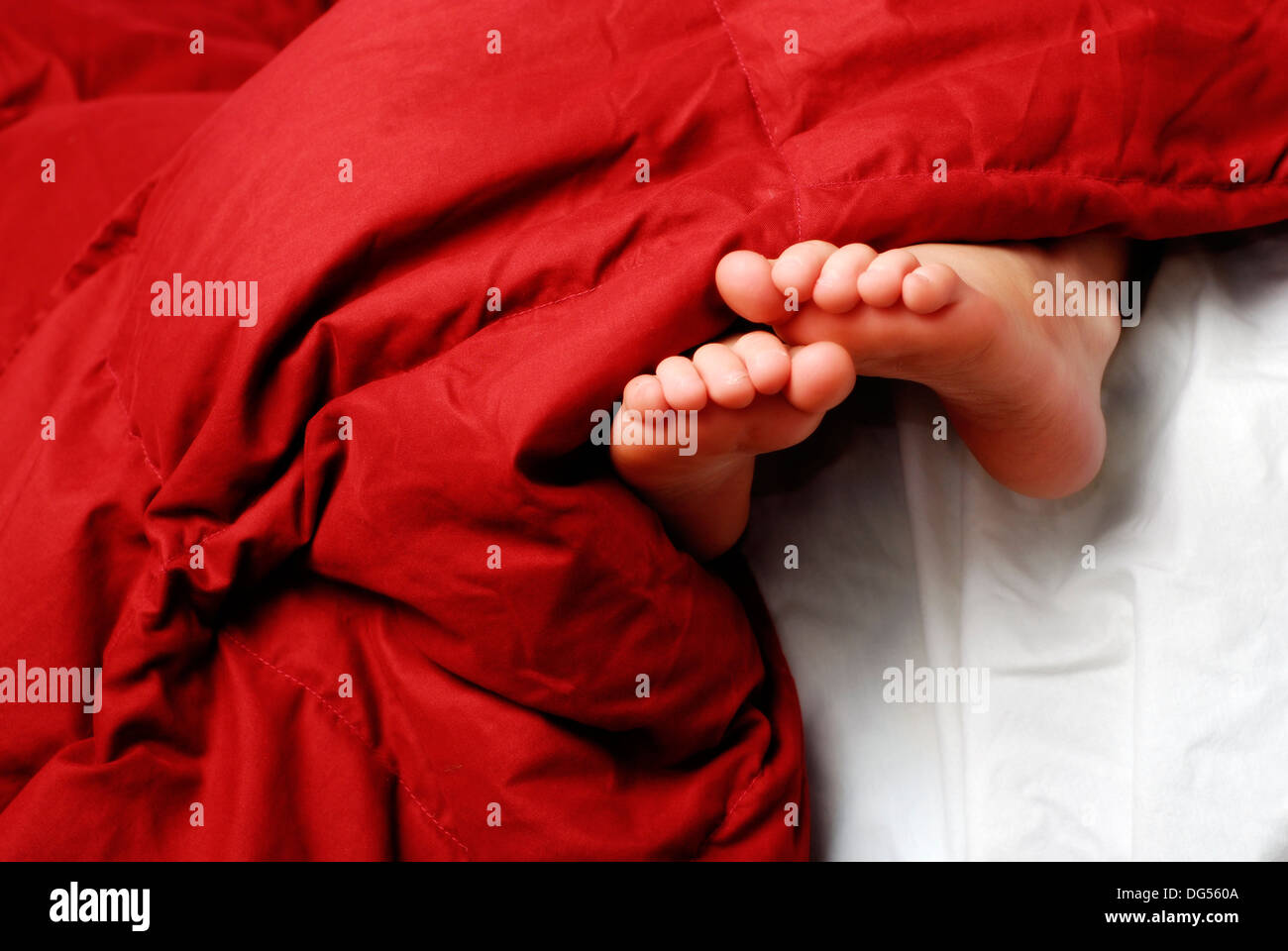 Little girl sleeping with feet poking out of blankets Stock Photo Alamy