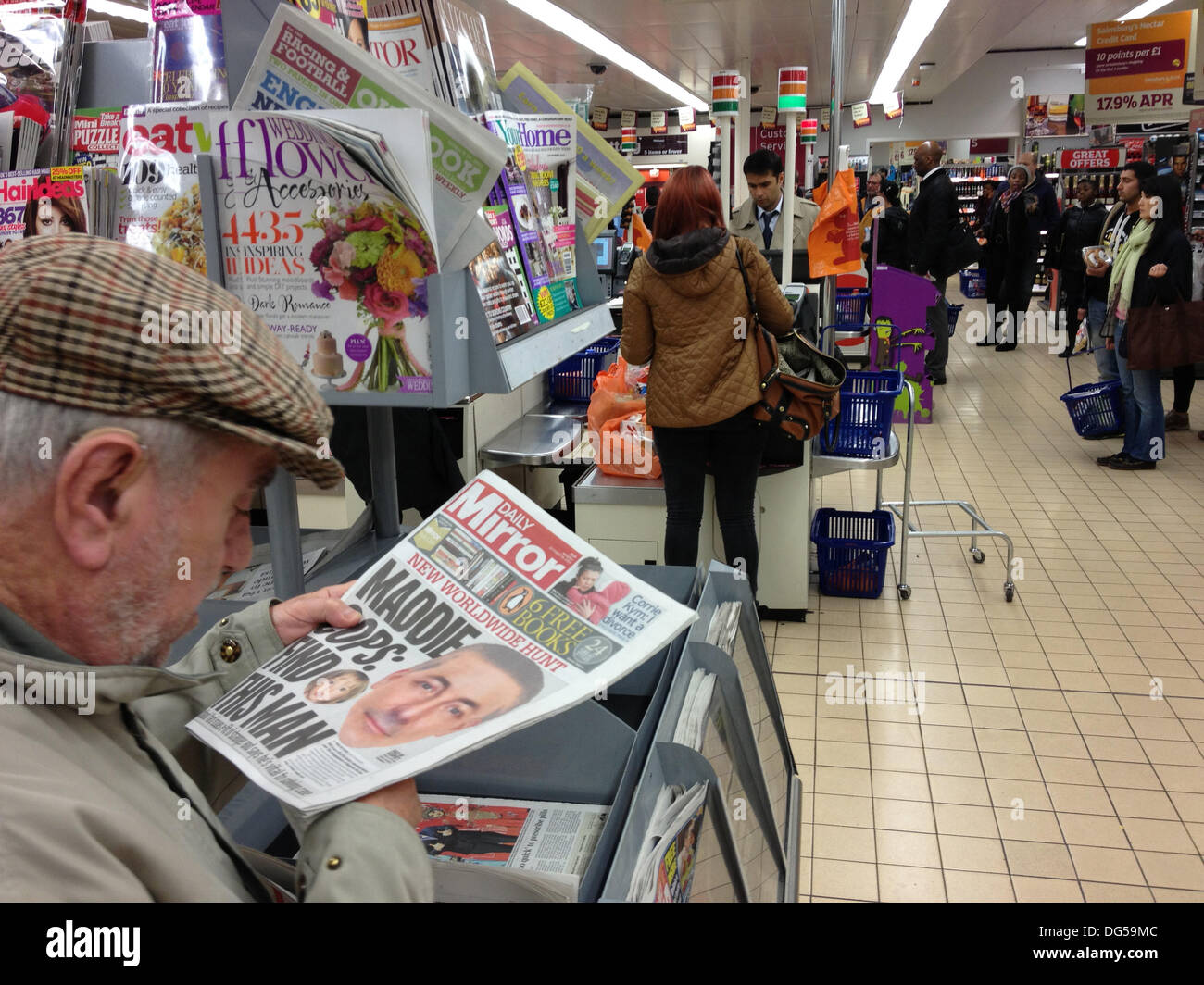 London UK. 14th Oct, 2013. A man reads A British newspaper headline showing one of the men wanted by the police in connection with the 2007 disappearance of Madeleine McCann Credit:  amer ghazzal/Alamy Live News Stock Photo