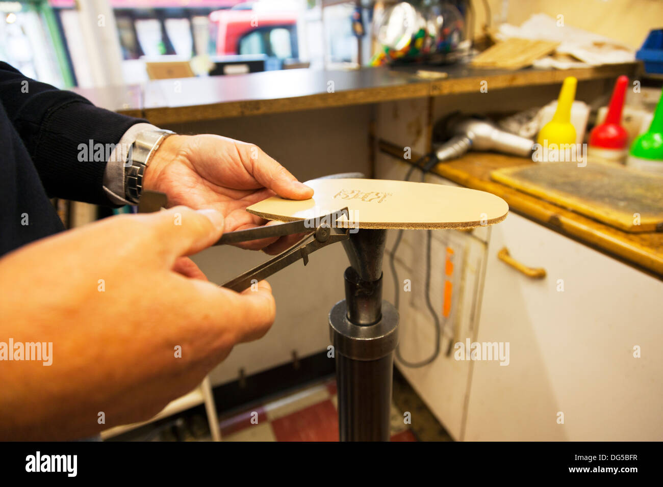 Male mans hands using micrometer to measure thickness of leather sole