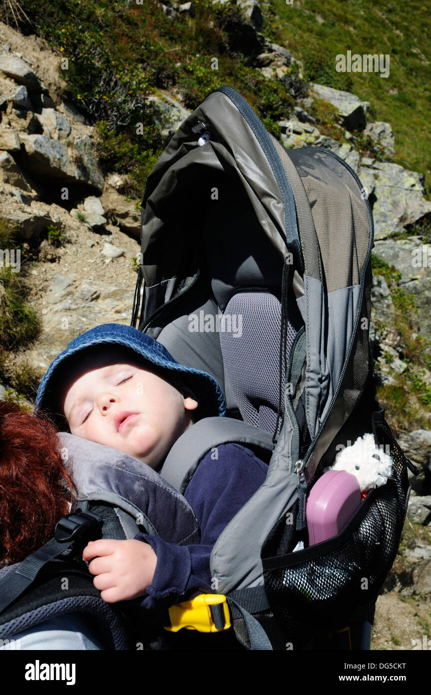 A baby fast asleep in a baby carrier Stock Photo