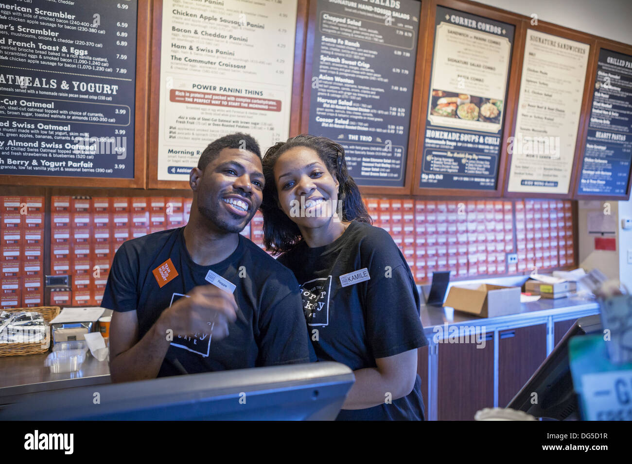 A man and woman happily pose while working at a bakery in Chicago. Stock Photo