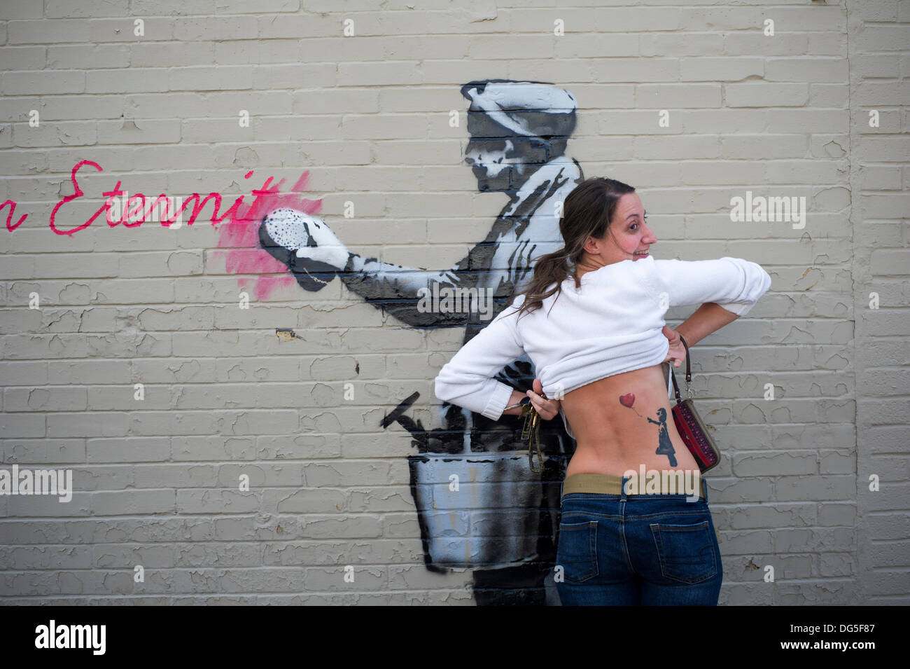 Queens, NY, USA . 14th Oct, 2013. A street art enthusiast shows off her  Banksy inspired tattoo in the Woodside neighborhood of Queens in New York  on Monday, October 14, 2013 in